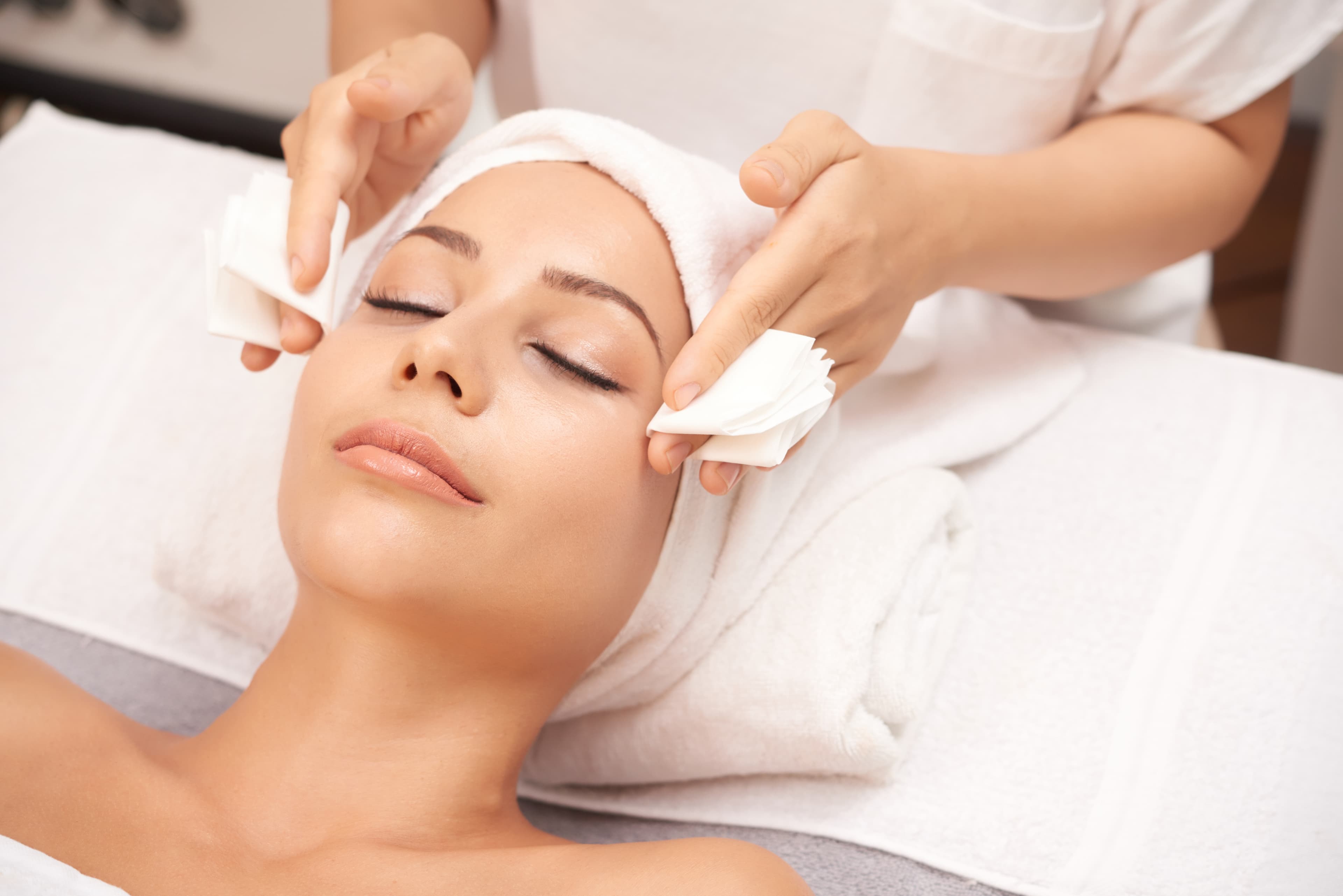 Cliente recibiendo un tratamiento facial en un ambiente relajante y profesional.